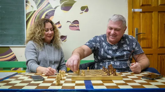 Valerii and Nataliia Shapovalov come with their grandchild to the heating point to play chess and give the child an opportunity to socialize. Photo: LWF/ L. Gillabert