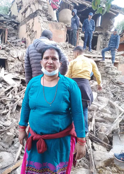 A woman stands in front of her collapsed house. Photo: Bhakta Raj Upadhyay/IP-USSBM Doti